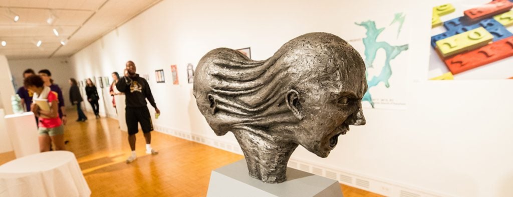 A sculpture of two heads facing away from each other which are connected at the back.