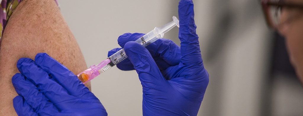 Closeup of an injection being given in a person's arm.