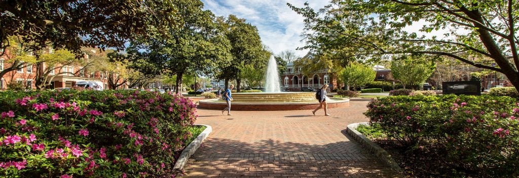 Students walking in front of a fountain on ECU's campus.